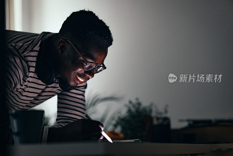 Smiling BusinessmanÂ Working At Home On A Digital Tablet